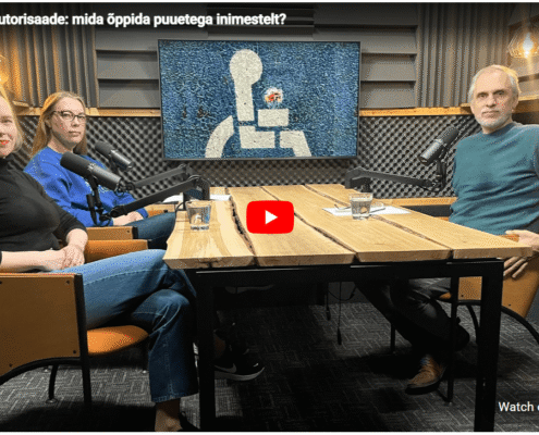 Podcasti stuudios istuvad laua taga vasakul 2 naisterahvast ja parem meesterahvas. Taustal televiisor, kuhu on kuvatud ratastoolimärk
